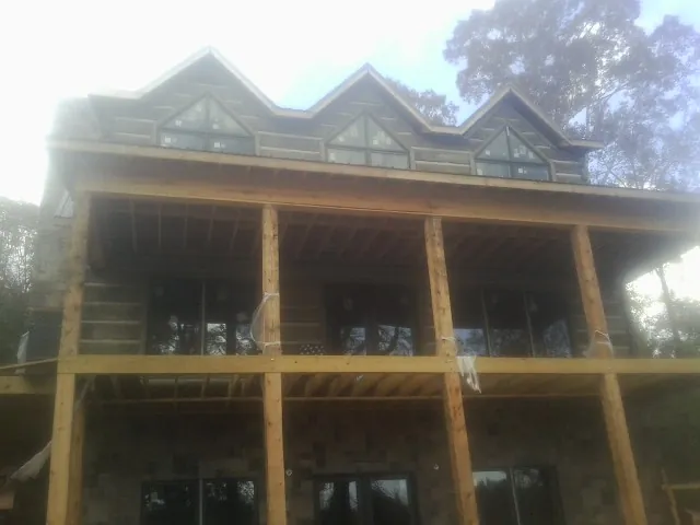 Dormers and porch framing on a large log home under construction — Roof Coating work by our crew in Broadview Heights