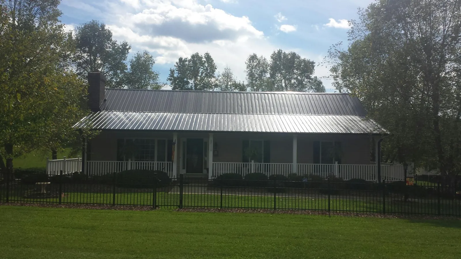 Gray metal roof on a brick ranch with a full width front porch — Gutter Guard Installation work by our crew in Broadview Heights