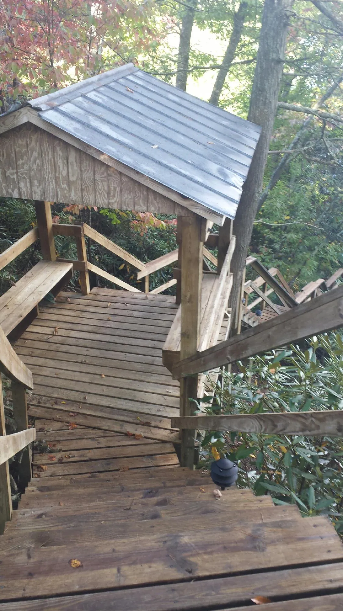 Metal roofed shelter over wooden steps on a wooded walkway — Skylight Repair & Installation work by our crew in Broadview Heights
