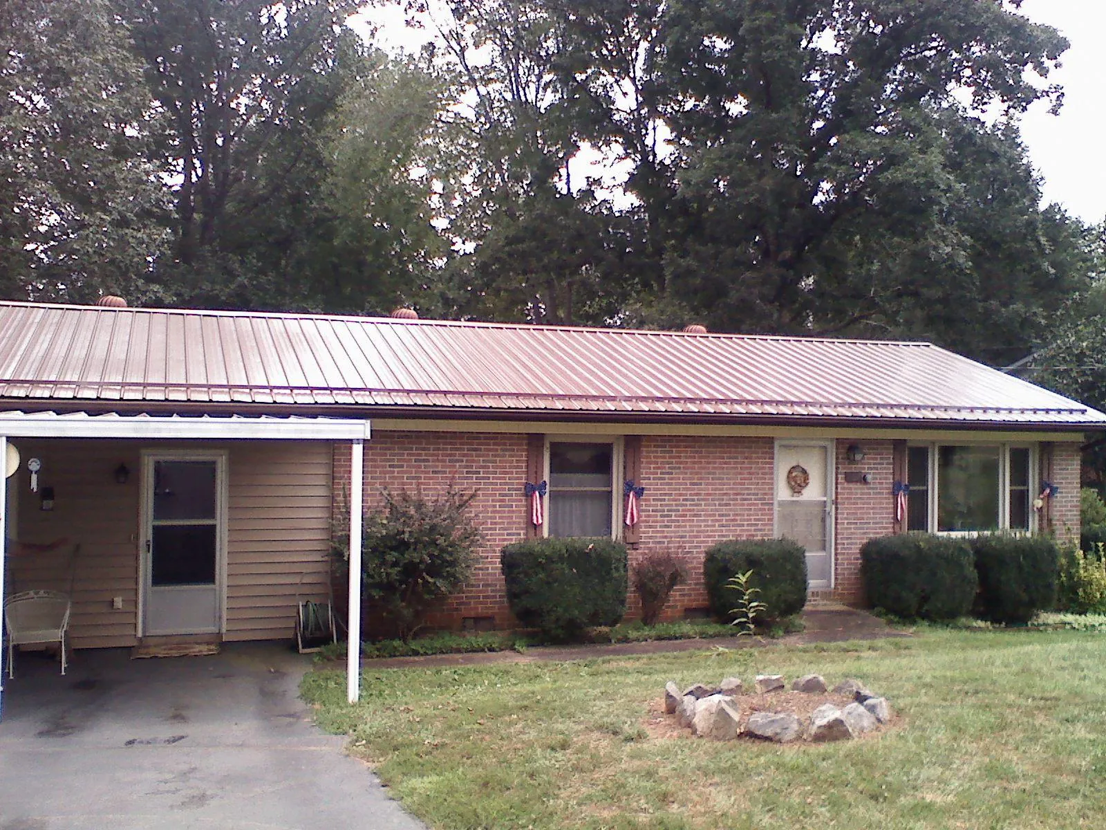 Bronze metal roof and carport on a brick ranch home — Roof Repair work by our crew in Broadview Heights